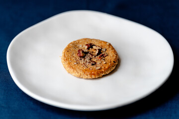 Walnut cookie on a white plate - side view