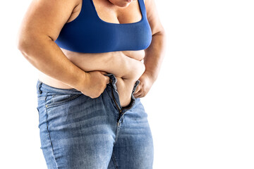 A fat woman has trouble buttoning her jeans - Isolated on white