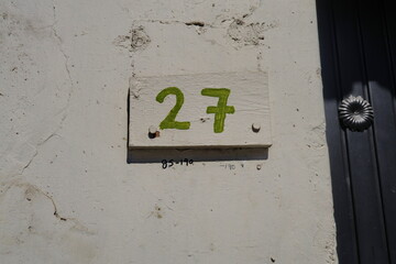 Numéro 27. Chiffres jaunes sur façade blanche