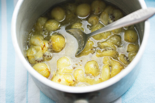 Boiling gooseberry with safron and honey. Making gooseberry compote 
