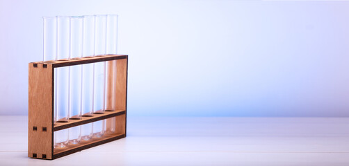 Empty glass test tubes on a wooden stand on the table. Empty glass tubes for testing in the laboratory