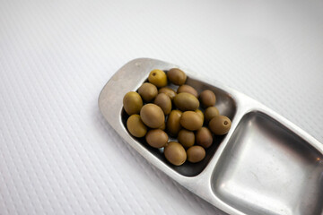 Vibrant green Alentejan olives adorning a restaurant table, capturing the essence of Portugal's culinary delights. A tempting taste of the Mediterranean.
