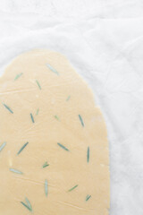 Top view of sugar cookie dough rolled between parchment paper, process of making cut out sugar cookies