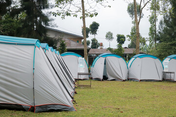 Camping and tent in the riverside. Natural area with trees and green grass