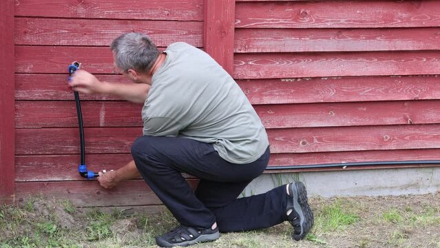 Installation of an external water supply using elbow fittings with compression collet clips for polyethylene pipes.