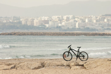Fototapeta premium Abandoned bicycle stands on rocks by the sea