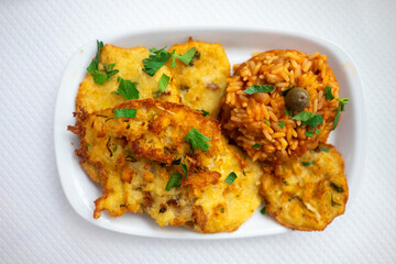 Capture the essence of Alentejo with a classic Portuguese delight: crispy cod fritters served with flavorful tomato rice. A taste of tradition!