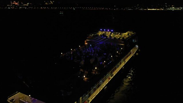 4K footage of drone gliding over sailing passenger tourboat on Istanbul Strait during night stock video.