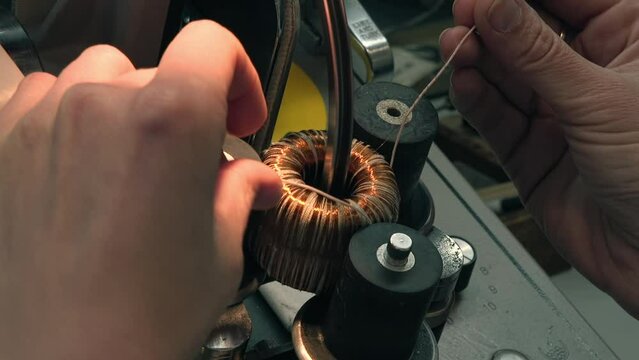Worker Winds Copper Wire On Coil For Engine Manufacturing. Electric Equipment Production. Coiling Copper Wire To Make Engine. Copper Wire On Engine Mechanism. Engineering. Factory Machine. Industry