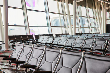 Generic view of empty airport seats at terminal with blown out windows - obrazy, fototapety, plakaty