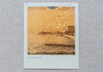 Detail of chemical weathering on Polaroid surface. Vintage Instant print close up. Lake Como town, Italy in the picture. - 637517389