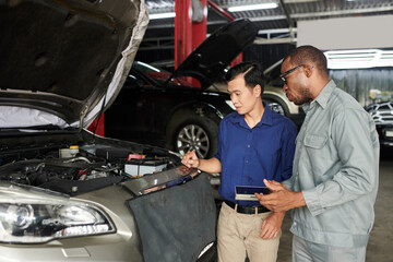 Man asking auto mechaninc to examine and fix his car