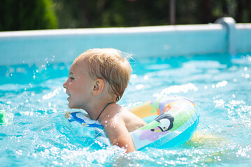 Little girl learning to swim in indoor pool with pool board