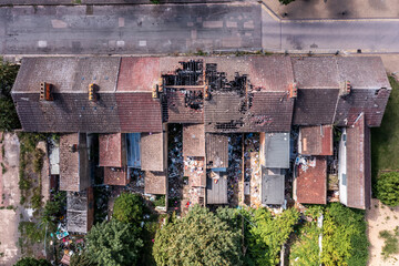Aerial view directly above the damaged roof of derelict terraced houses after a house fire © teamjackson