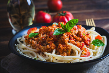 Spaghetti pasta and tomato sauce with chicken mince on a wooden background. Pasta bolognese.
