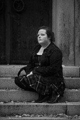 A woman sitting in step in front of a gate