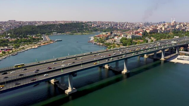 4K aerial panoramic shooting of Golden Horn of Istanbul. Drone zooming in towards Atat&uuml;rk Bridge over Golden Horn in sunny daylight against Ey&uuml;p stock video.