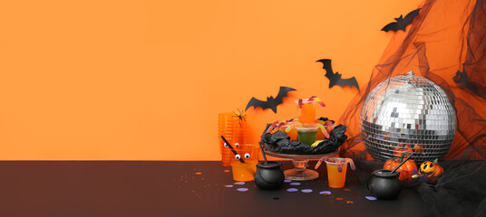 Creative cocktails and decor prepared for Halloween party on orange background. Banner for design