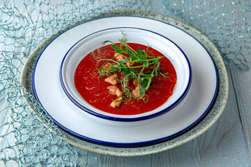 Cold tomato gazpacho soup on a blue background. Mediterranean Kitchen. Sea mood menu.