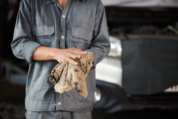 Cropped image of car service worker wiping off motor oil from hands