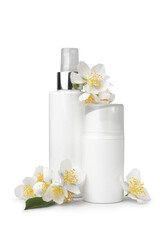 Obraz na płótnie Canvas Bottles of cosmetic products and beautiful jasmine flowers on white background