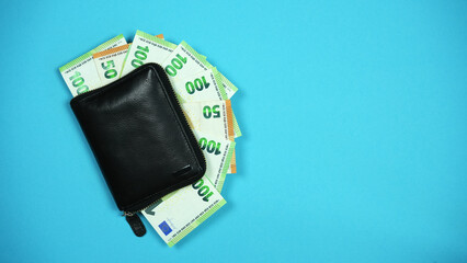 Black leather men's wallet with money. Purse with a pack of 100 euro bills.