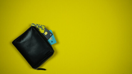 Black Leather Wallet with Credit Cards On Yellow Backround. Top View. Space For Text
 - obrazy, fototapety, plakaty