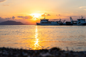 Fototapeta premium Ships and boats in harbour at sunset at the Greek island of Evia