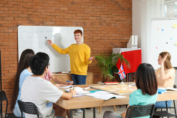 Male teacher conducting lesson to young students at language school