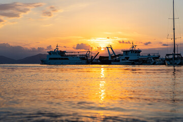 Fototapeta premium Ships and boats in harbour at sunset at the Greek island of Evia