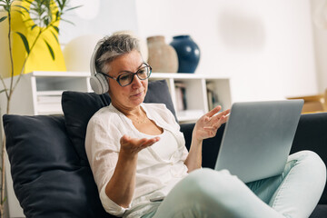 Elderly Caucasian woman is having a video call via laptop.