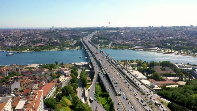 4K aerial shooting of Golden Horn of Istanbul. Drone zooming out from Atat&uuml;rk Bridge over Golden Horn in sunny daylight against the historical walled city and Ey&uuml;p stock video.
