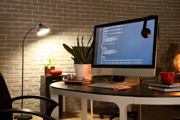 Programmer's workplace with computer in dark office