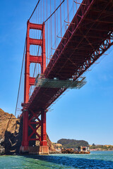 Underside view of Golden Gate Bridge on bright summer day with clear blue skies