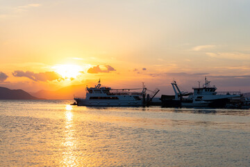 Ships and boats in harbour at sunset at the Greek island of Evia