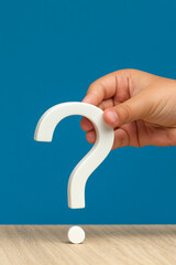 The eternal question, the unknown or the search for an answer. A hand holding a white question mark...