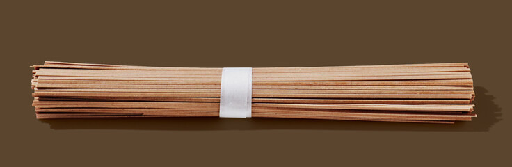 Bunch of spaghetti on brown pastel background.