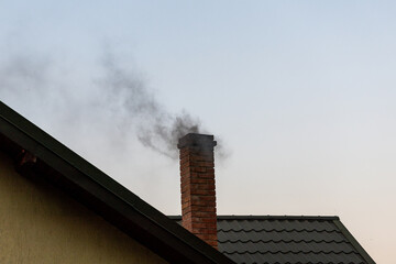 Smoke from chimney on a house roof. Environment, pollution, global warming concepts