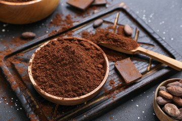 Bowl with cocoa powder on black background