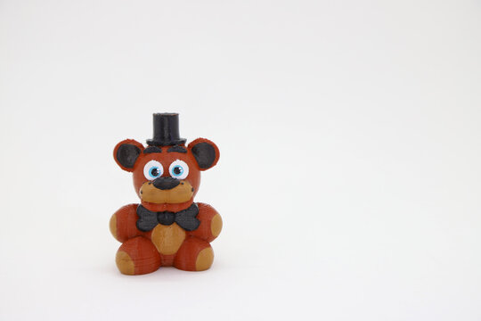 Five Nights at Freddy's doll printed on a 3d printer. Scary bear toy from the video game on white background and with room for copy space.