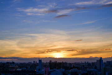都市の夜明け。東の空が明るくなり雲がまだ昇る前の太陽に照らせら美しいグラデーションを見せる。神戸市内から大阪方面を臨む。