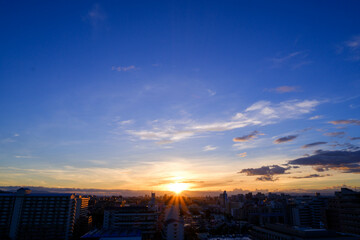 都市の夜明け。東の空が明るくなり雲がまだ昇る前の太陽に照らせら美しいグラデーションを見せる。神戸市内から大阪方面を臨む。
