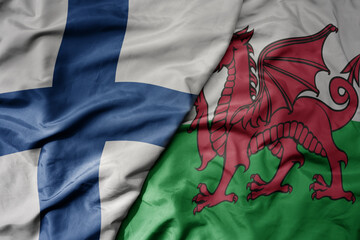 big waving national colorful flag of finland and national flag of wales .