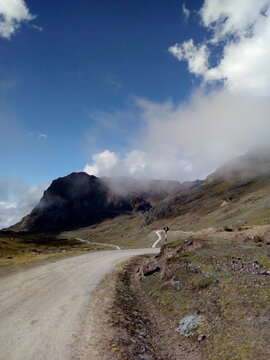 fondo de camino, trocha hacia las monta&ntilde;as, con cielo azul y nubes, caminata, viaje, sierra, gran camino, soleado.