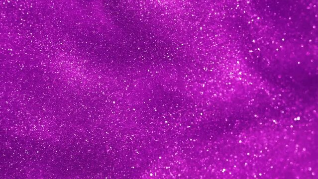 Purple liquid with tints of silvery glitters. Purple background with a scattering of bright sparkles. Magic Galaxy of shiny dust particles in fluid. Slow Motion 4K background.