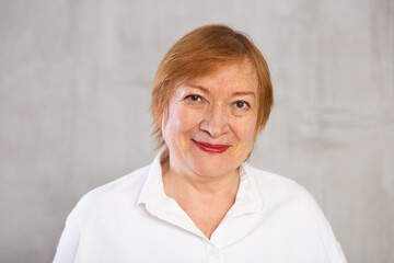 Older woman standing proudly with happy confident grin