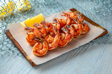Grilled king prawns on a blue background. Mediterranean Kitchen. Sea mood menu.
