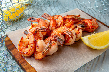 Grilled king prawns on a blue background. Mediterranean Kitchen. Sea mood menu.