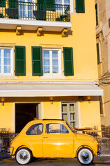 22 August 2022 - Corfu, Kerkira: Yellow Fiat 500 vintage model old timer car sixties parked in a...