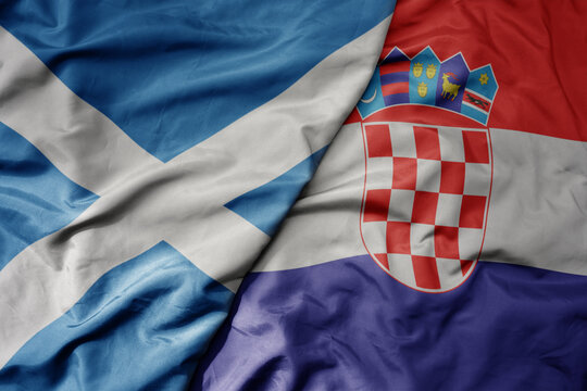 big waving national colorful flag of scotland and national flag of croatia .